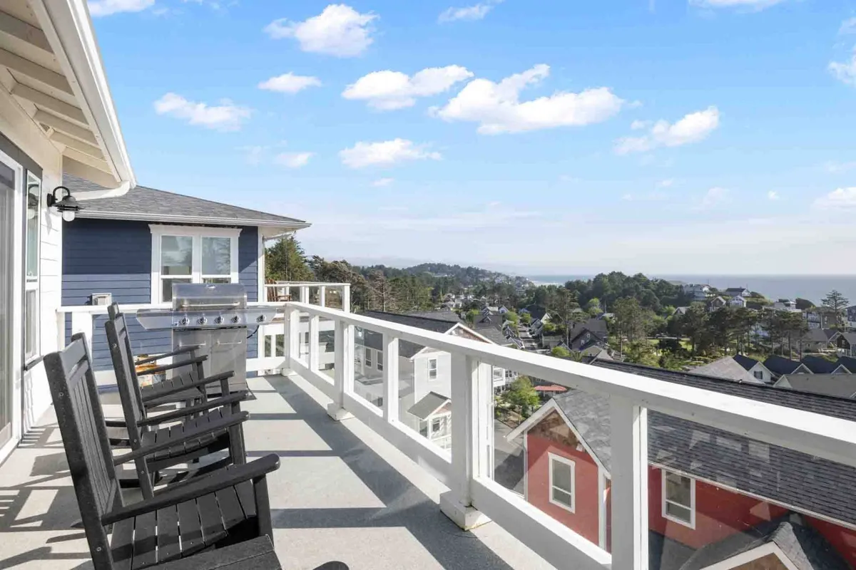 A tranquil exterior deck outfitted with comfortable deck chairs and a grill, all overlooking a stunning ocean view. The scene suggests an inviting atmosphere for outdoor relaxation, barbecues, and soaking in the coastal ambiance.